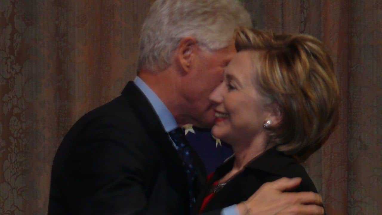 Bill Clinton leans in to talk to Hillary.