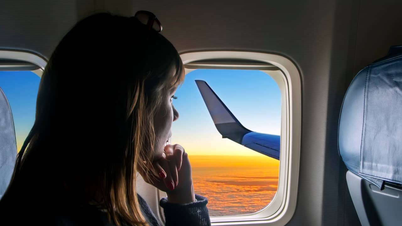 Woman looking out the window during her flight