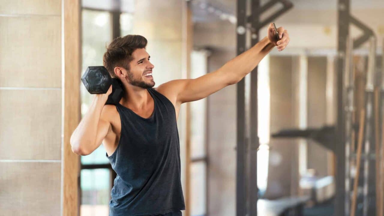 Fitness man makes selfie in gym with weight