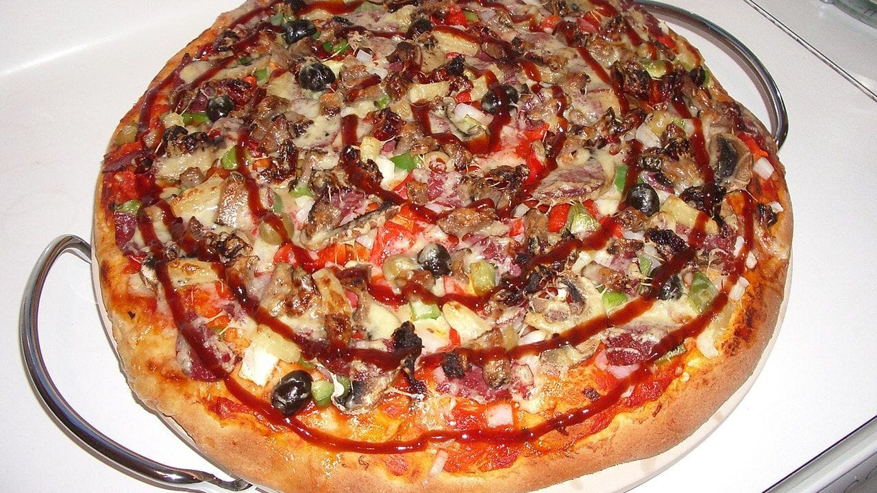Meatlovers pizza with Beef, Pepperoni, Red and Green Capsicum, Olives, Sun-dried tomatoes and Pineapple, topped off with cheese and a swirl of BBQ sauce