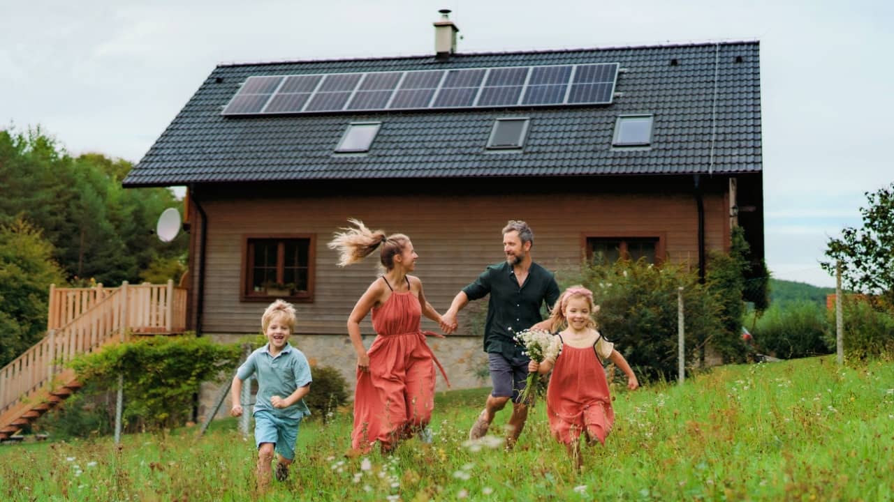 Happy family running near their house with solar panels